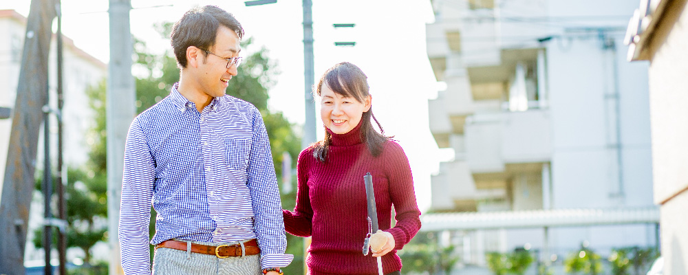 みちしるべの職員が利用者さんと歩行訓練をしている写真。