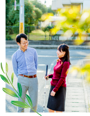 歩行訓練中の利用者さんが訓練士と談笑している写真。